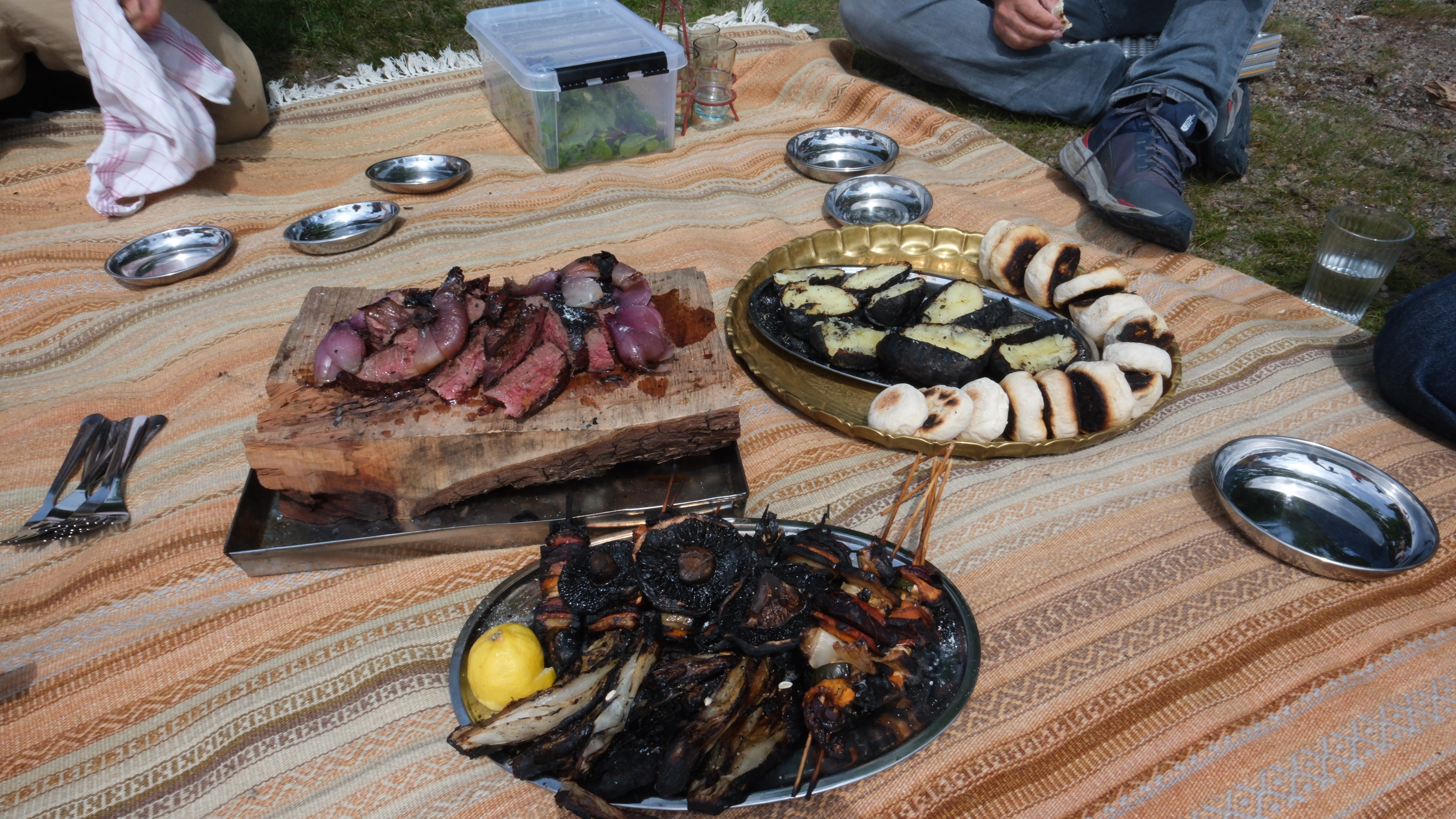 Feuerküche auf dem Granit mit Fleisch, Gemüse und Muscheln