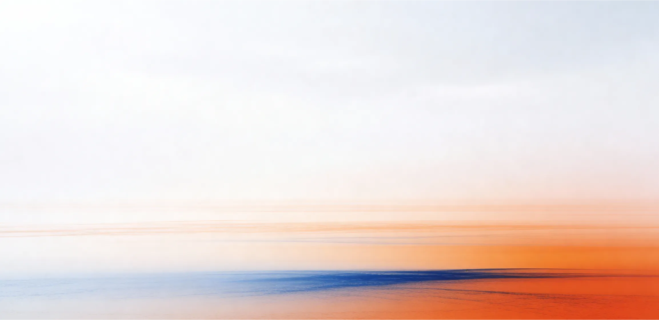 Abstract blurred gradient with blue at the bottom blending into orange and white above.