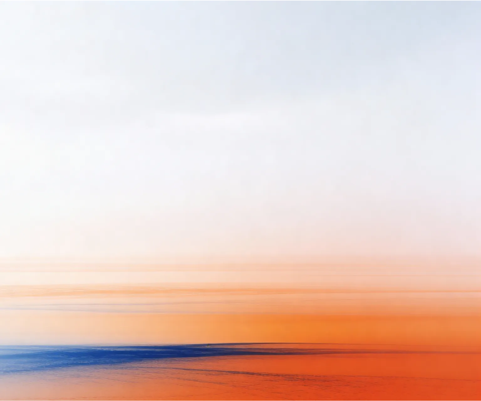 Abstract blurred gradient with blue at the bottom blending into orange and white above.