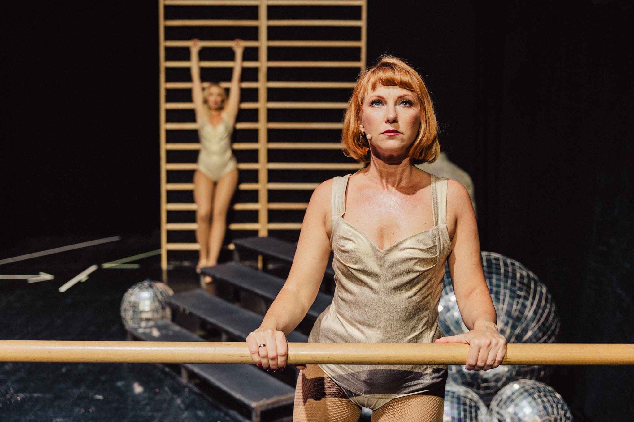 Aktorka wisząca na drabinkach i druga stojąca przy drążku. Fot: Marek Zimakiewicz