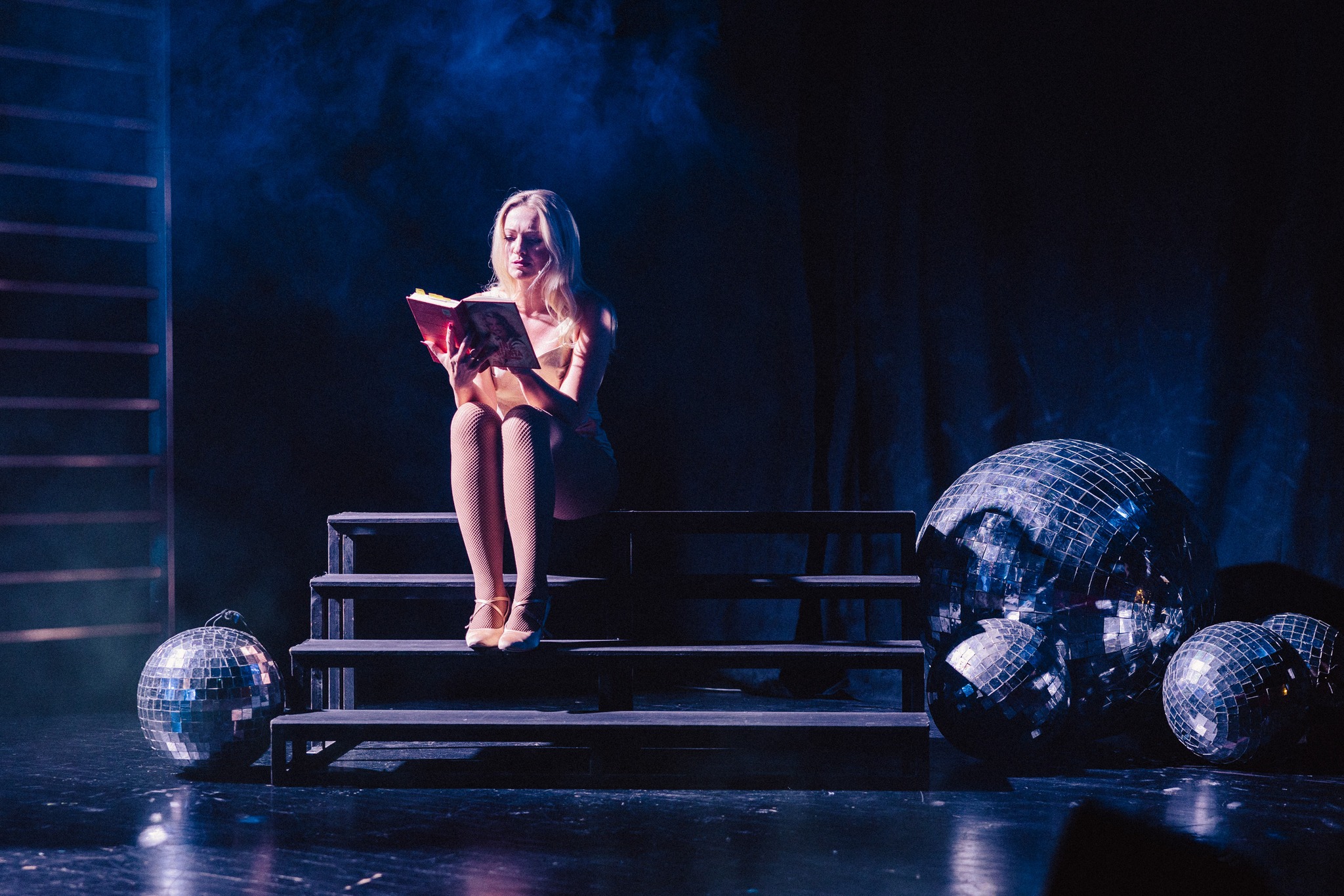 Aktorka czytająca książkę na schodach. Fot: Marek Zimakiewicz