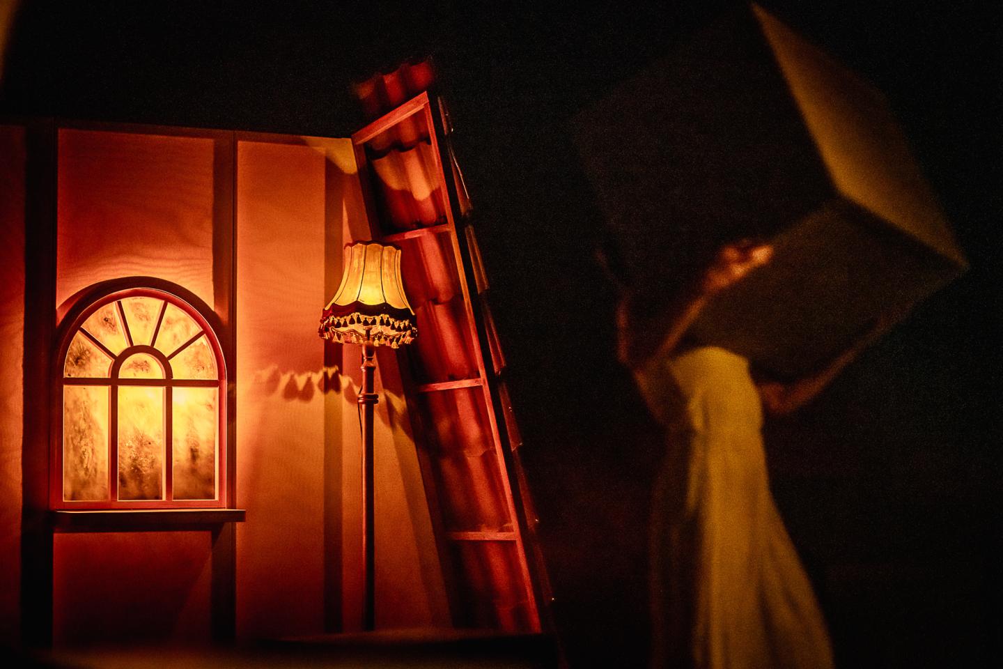 Ujęcie na okno znajdujące się na scenie w ciemnym i ciepłym świetle. Fot. Maciej Zakrzewski