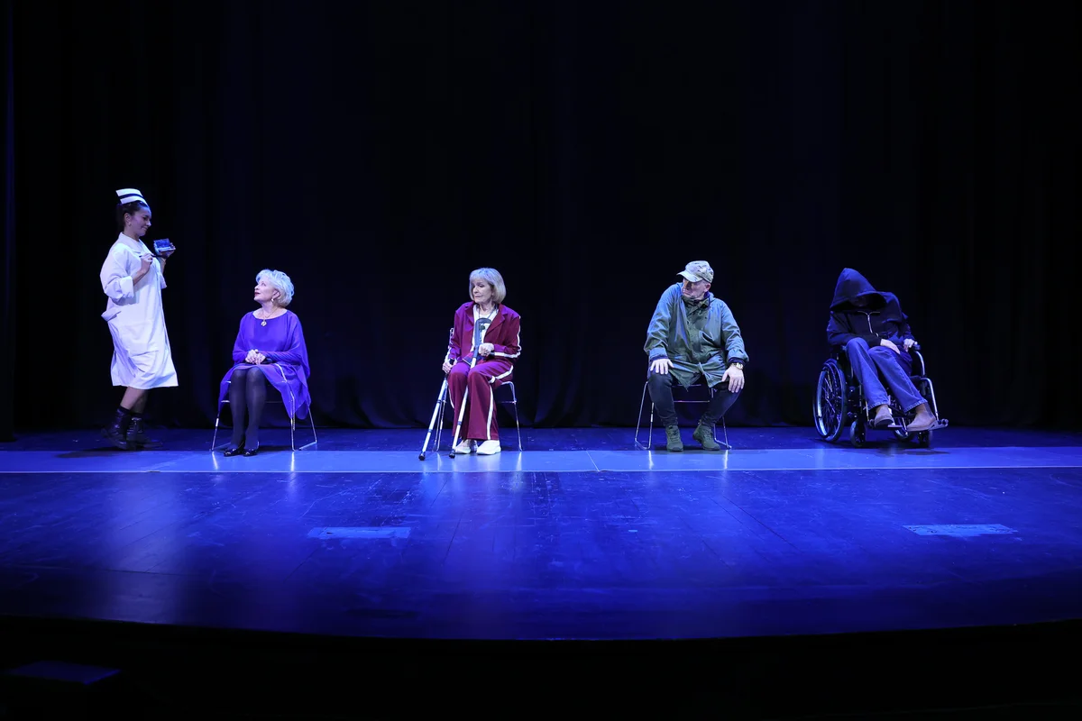 Scena zbiorowa, aktorzy siedzą na krzesłach, pielęgniarka stoi. Fot. Katarzyna Kural-Sadowska