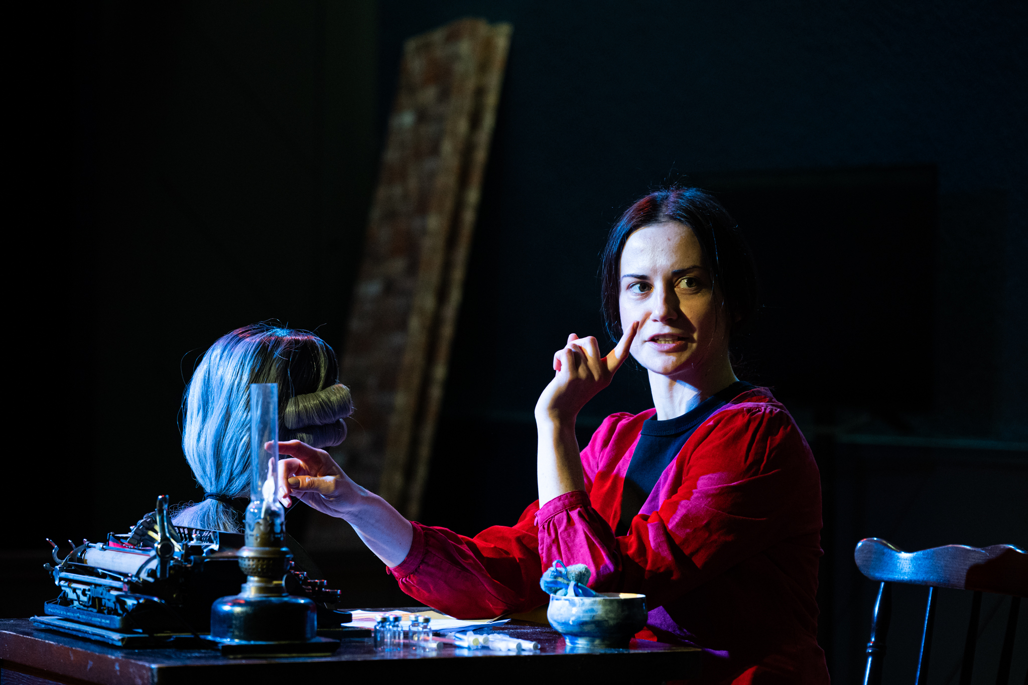 Aktorka siedząca przy stole. Fot. Kornelia Głowacka-Wolf