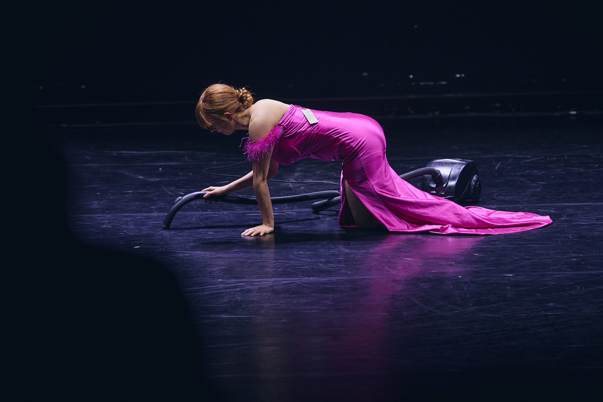 Aktorka w strojnej sukni odkurza na czworakach. Fot: Jan Rusek