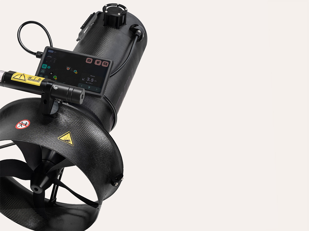 Black underwater scooter with propeller, mounted digital display, and warning labels on carbon fiber body.