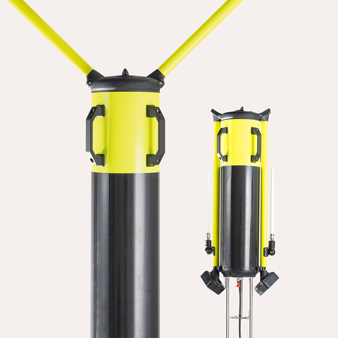 Close-up of two tall, cylindrical yellow and black buoy components with handles and mounting features against a white background.