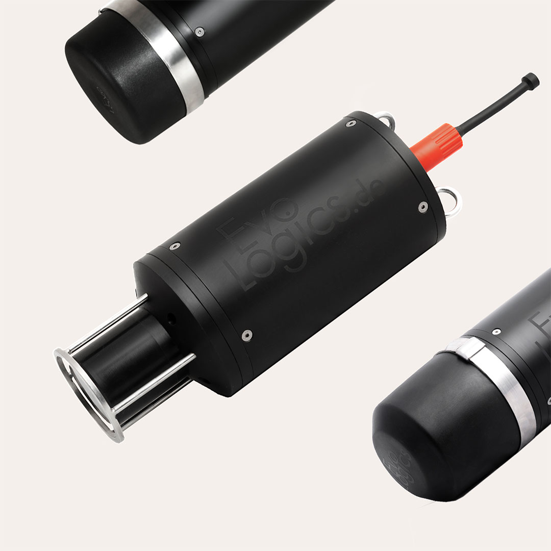 Three black cylindrical electronic devices with metal and red cable connectors on a light background.