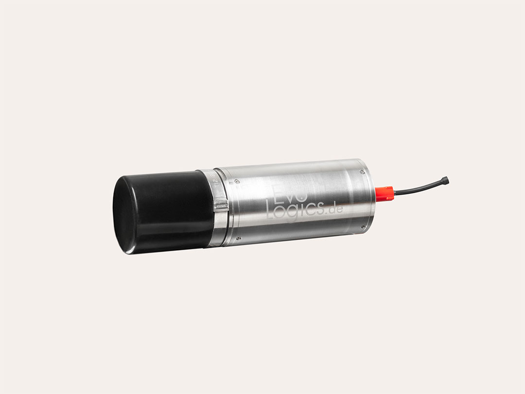 Silver cylindrical device with a black cap and a red connector attached to a black cable against a light background.