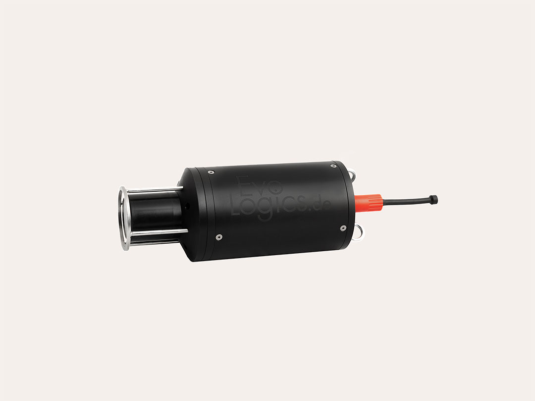 Black cylindrical device with metallic front and red cable connector on a light background.