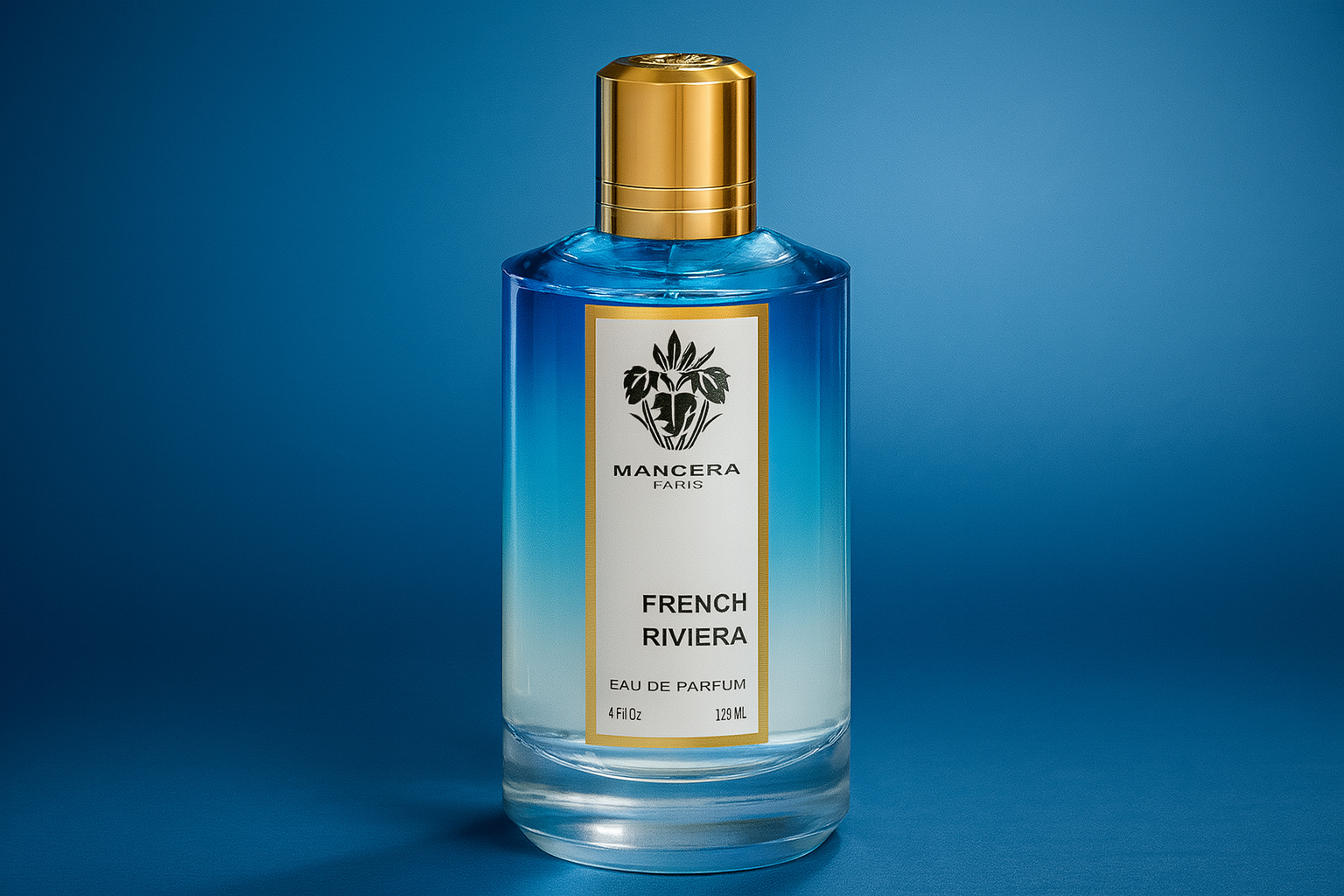  A realistic widescreen image of Mancera French Riviera Eau de Parfum bottle with a blue-to-clear gradient design, gold cap, and black text label, set against a soft blue gradient background.