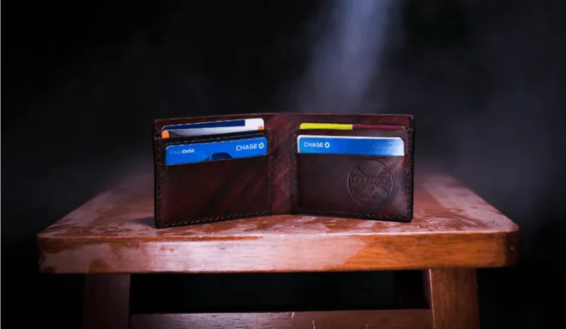A wooden table with a wallet on top of it.