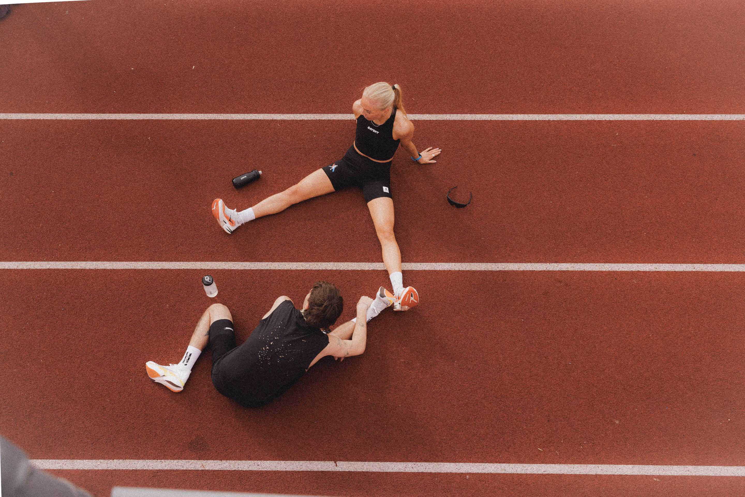 To utøvere tøyer etter trening med pace i drikkeflasken