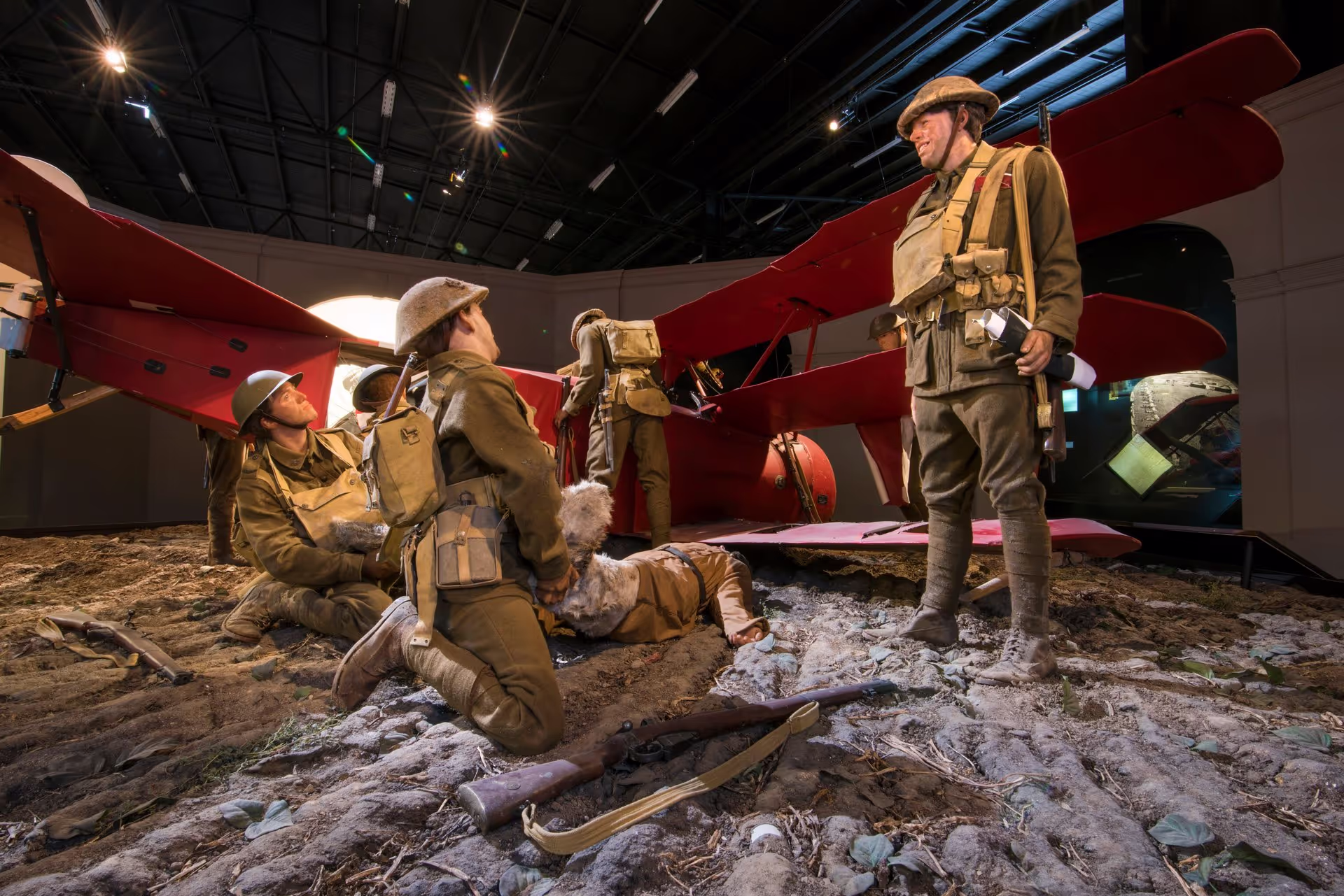 World War I exhibit with soldiers around a red biplane.