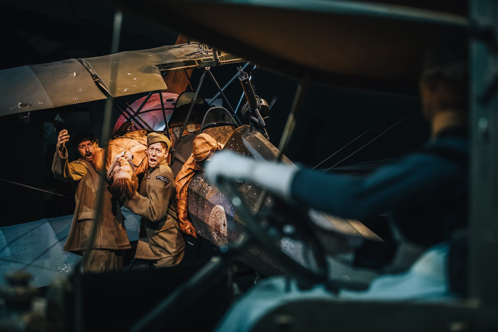 Vintage airplane with pilot and navigator in a cockpit, viewed through a side window.