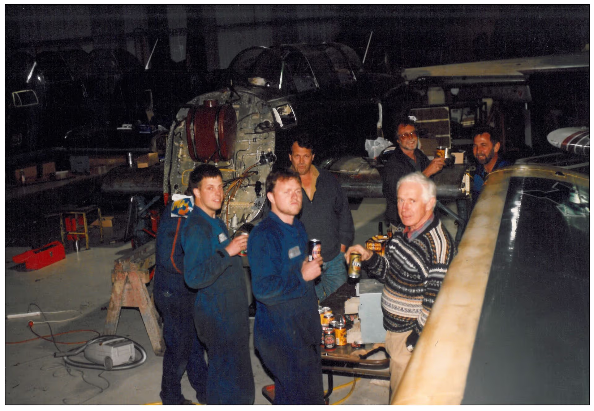 Group of people chatting in an industrial setting at night.