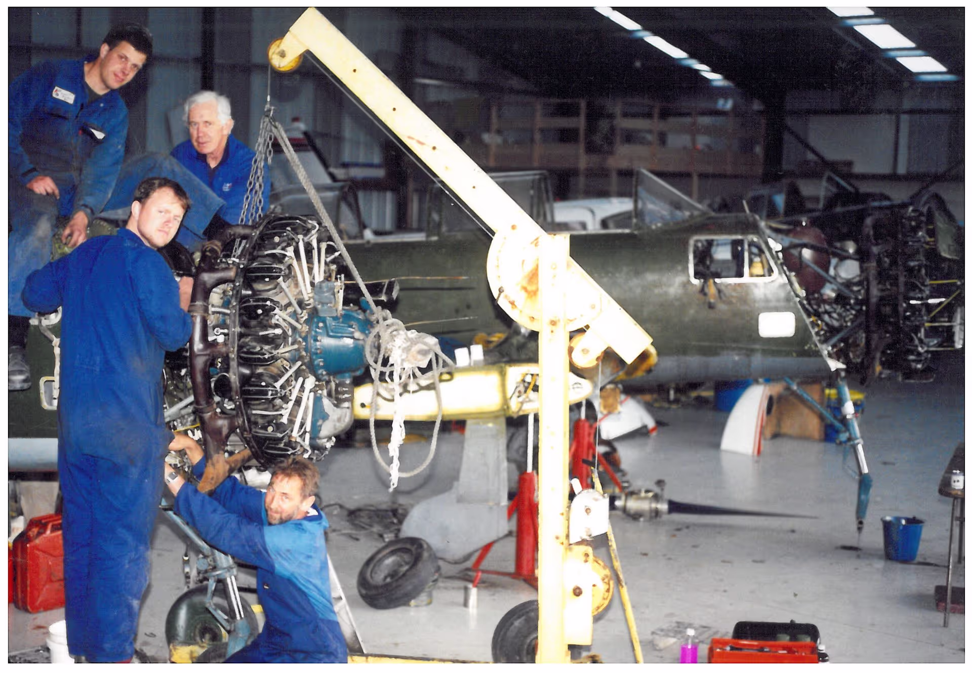 Technicians working on aircraft parts in a hangar.