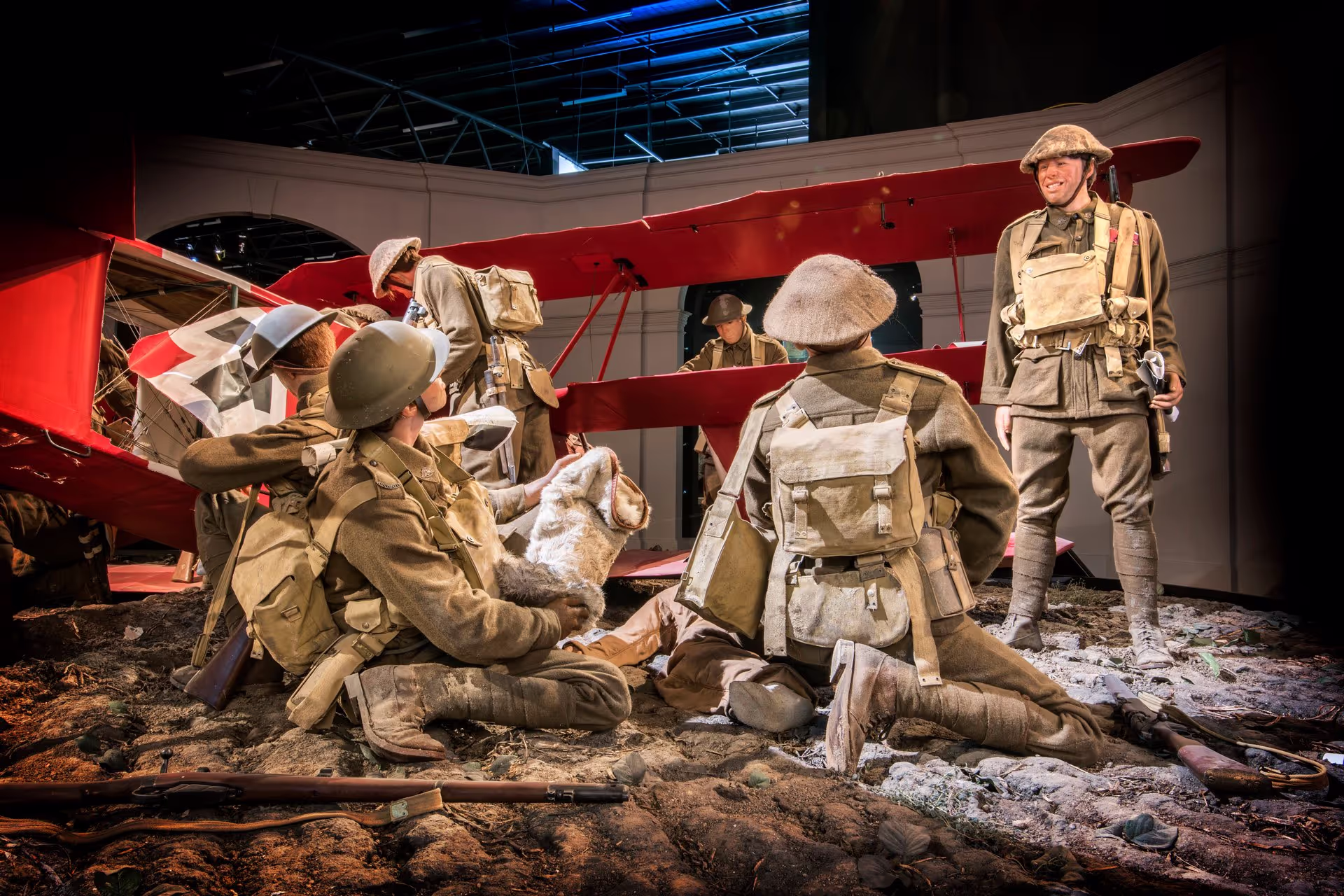 A vintage plane with uniform-clad figures and military gear in a staged wartime scene.