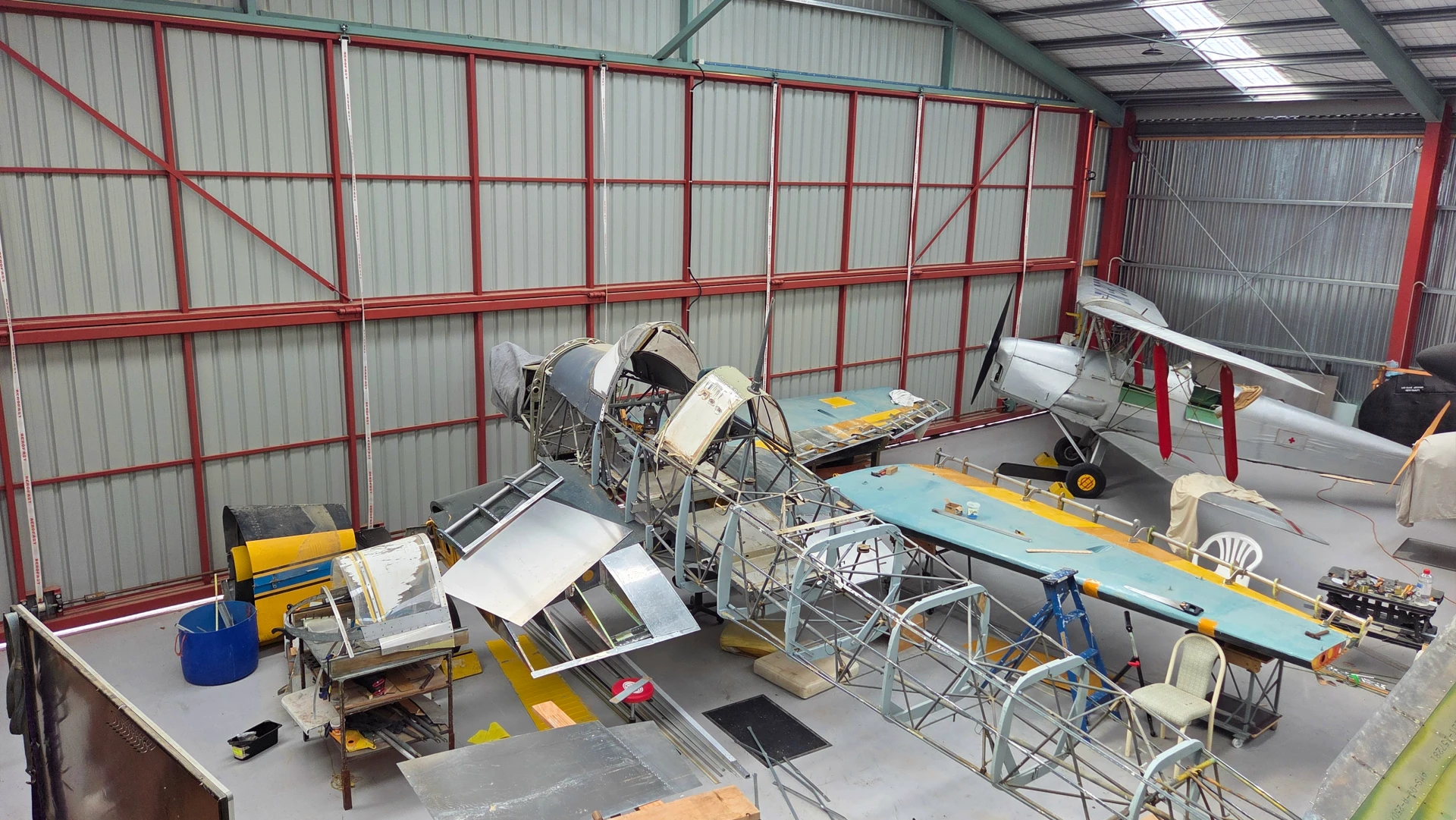 Shows the Omaka Hangar workshop floor with a Stuka fuselarge and a Tigermoth aircraft.