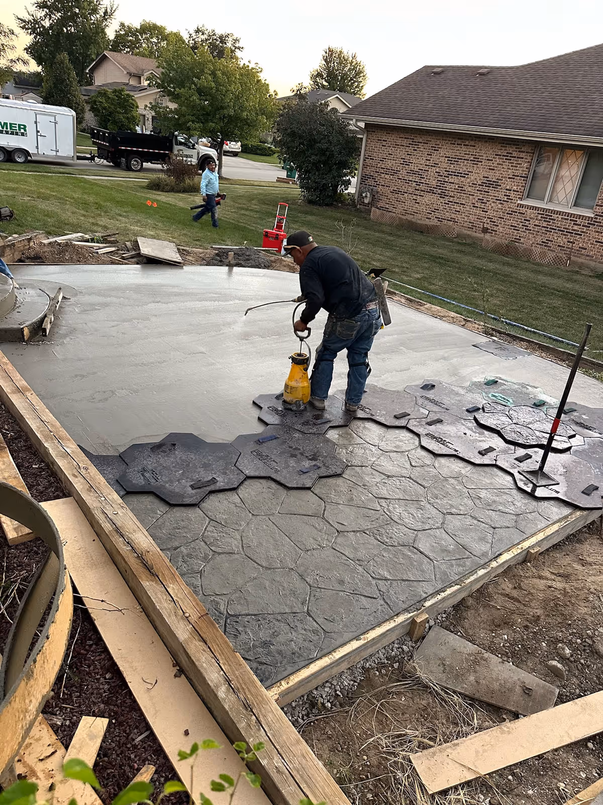 A patio installation is in progress by a concrete contractor at GoMulch for a Lockport home using stamped concrete.