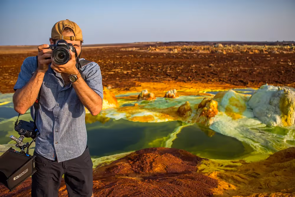 Man taking a photo in front of some salt pans