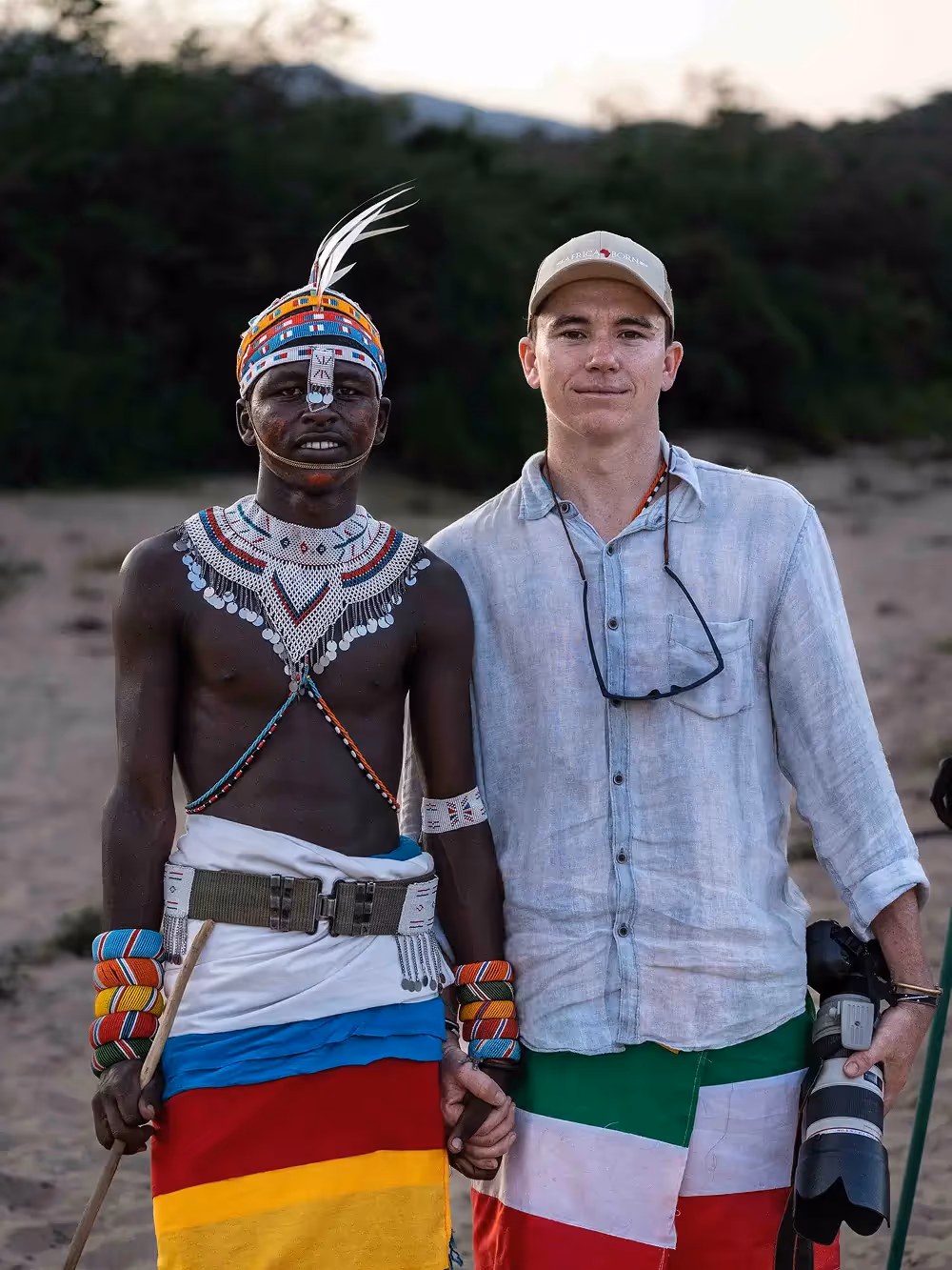 Man standing with a local wearing beads