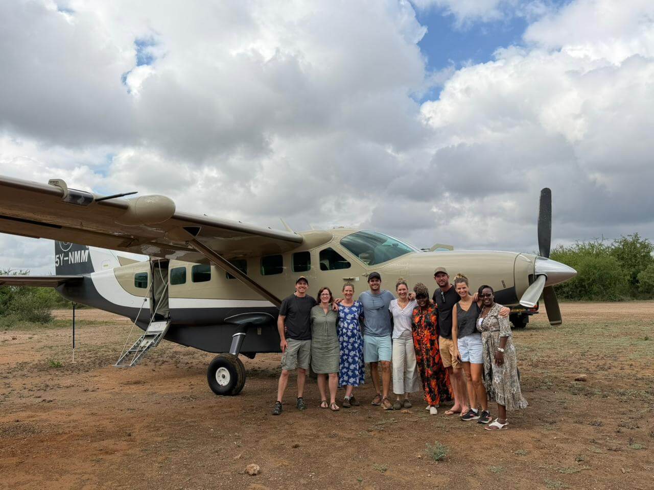 Group photo in front of plane