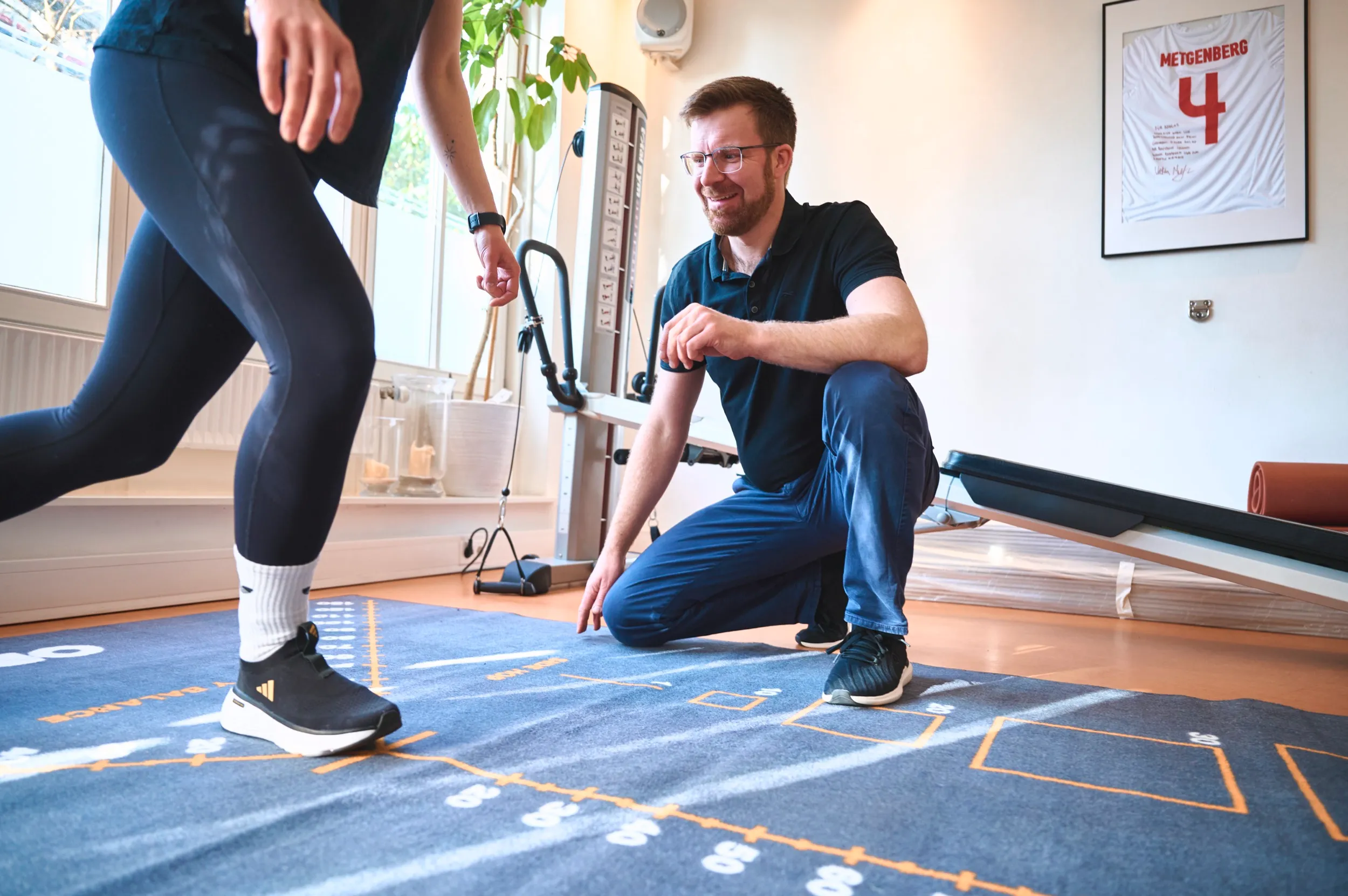 Physiotherapeut beobachtet Beinbewegung bei funktionellem Return-to-Sport Test in der PhysioLounge Hamburg