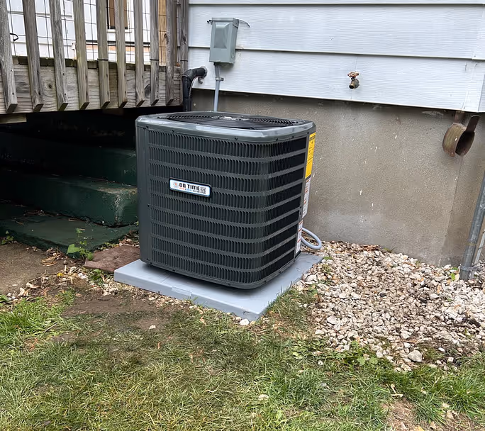 New outdoor air conditioning unit installed beside house.
