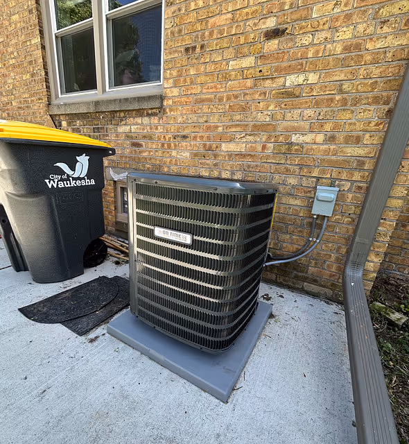 Outdoor AC unit newly installed & service next to brick house wall.