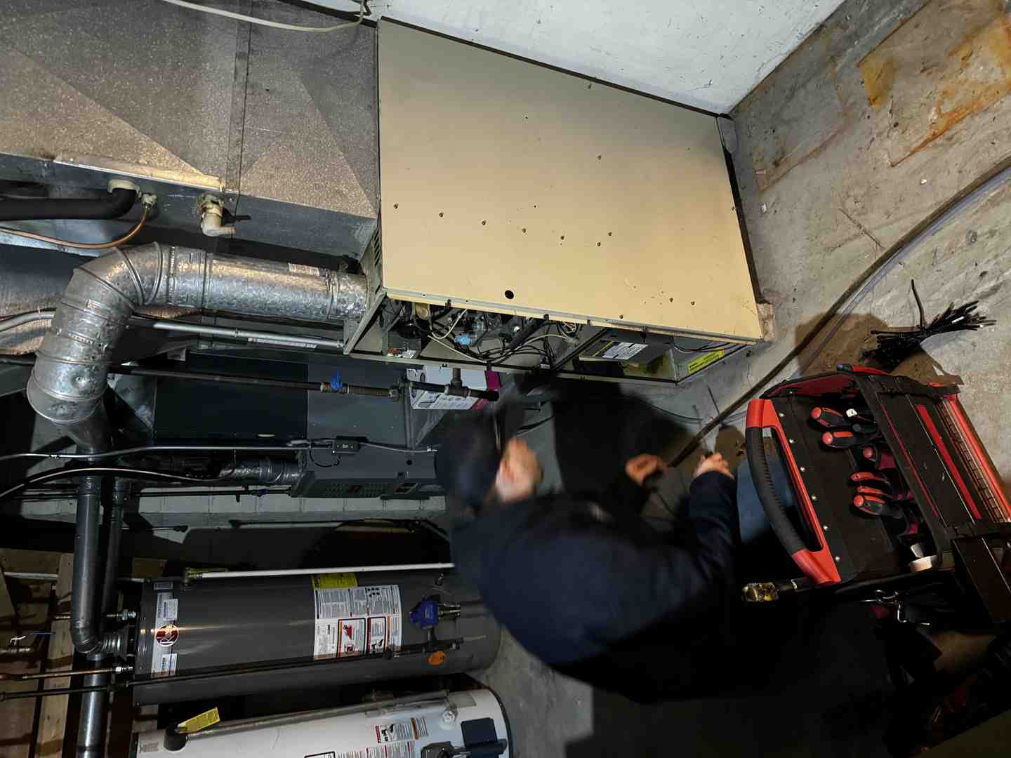 A technician with a clipboard inspecting a furnace, highlighting thoroughness - hvac maintenance plan waukesha wi