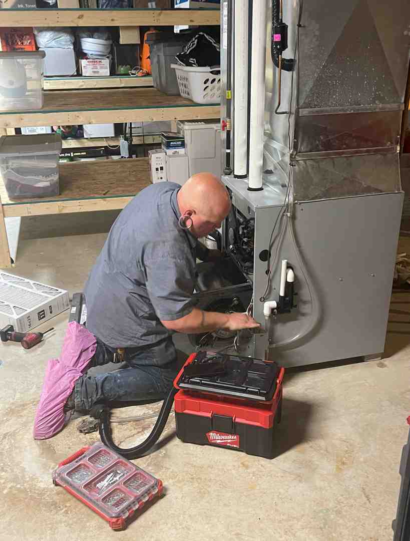 HVAC technician performing maintenance on a furnace - best furnace installation oconomowoc