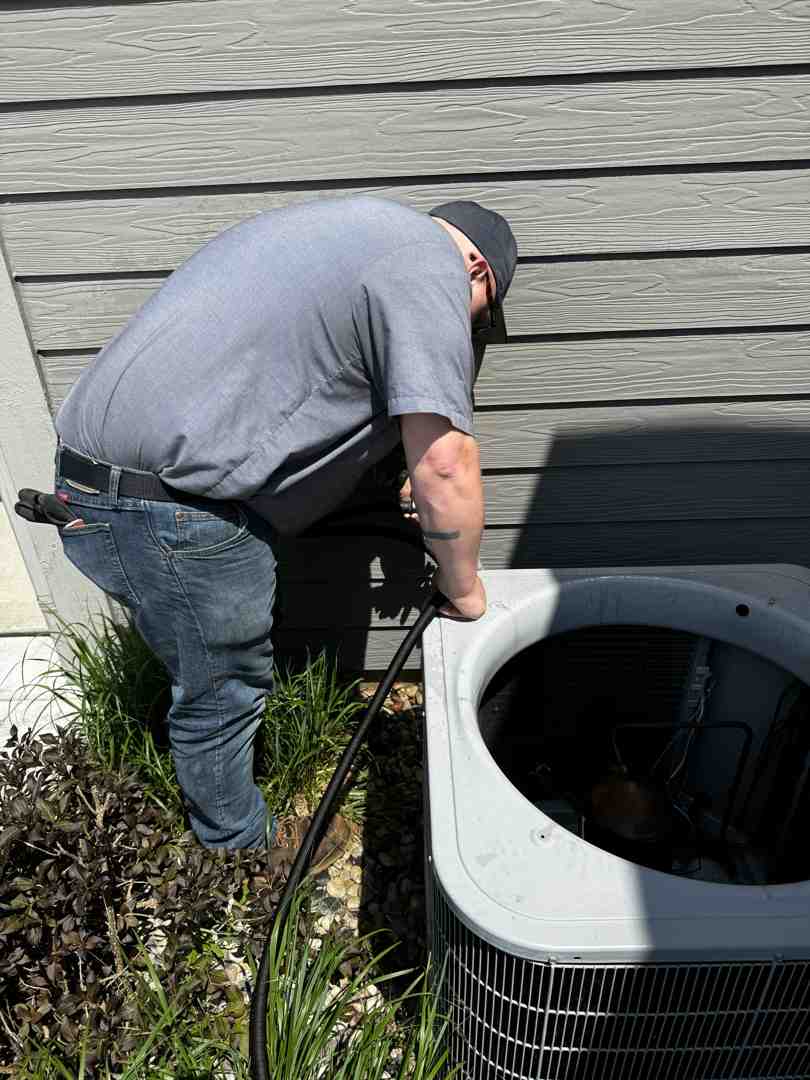 technician performing maintenance on an outdoor AC unit - hvac repair waukesha technician performing maintenance on an outdoor AC unit - hvac repair waukesha