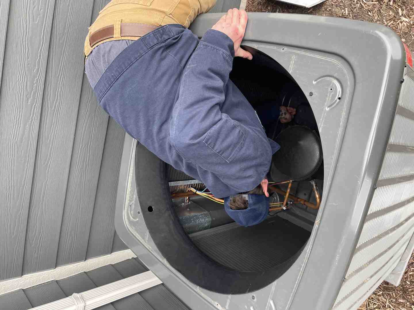 professional technician inspecting an outdoor AC unit - AC maintenance Pewaukee WI professional technician inspecting an outdoor AC unit - AC maintenance Pewaukee WI