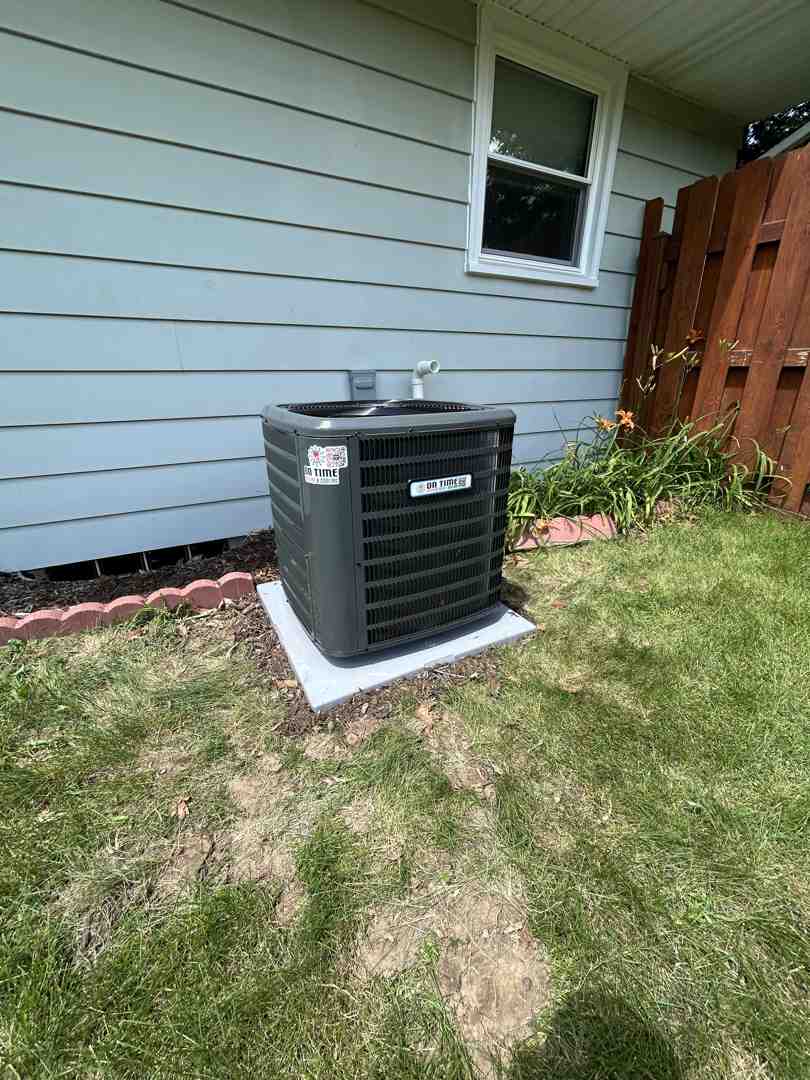 Outdoor HVAC condenser unit sitting on a concrete pad next to a home - central ac vs ductless mini split comparison