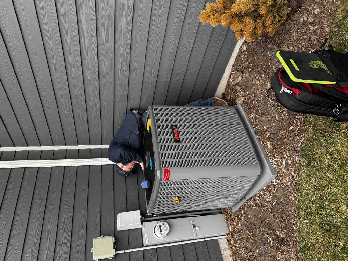 homeowner checking outdoor condenser unit