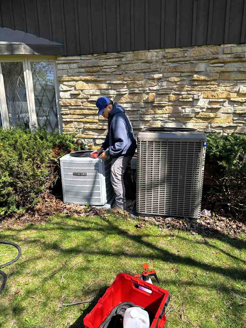 Professional HVAC technician performing a precision AC tune-up on a modern outdoor condensing unit - how being the fastest