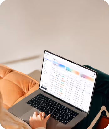 Person using laptop showing a data audit or analytics dashboard with tables and colorful metrics.