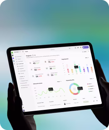 Hands holding a tablet showing an analytics dashboard with charts, numbers, and performance metrics.