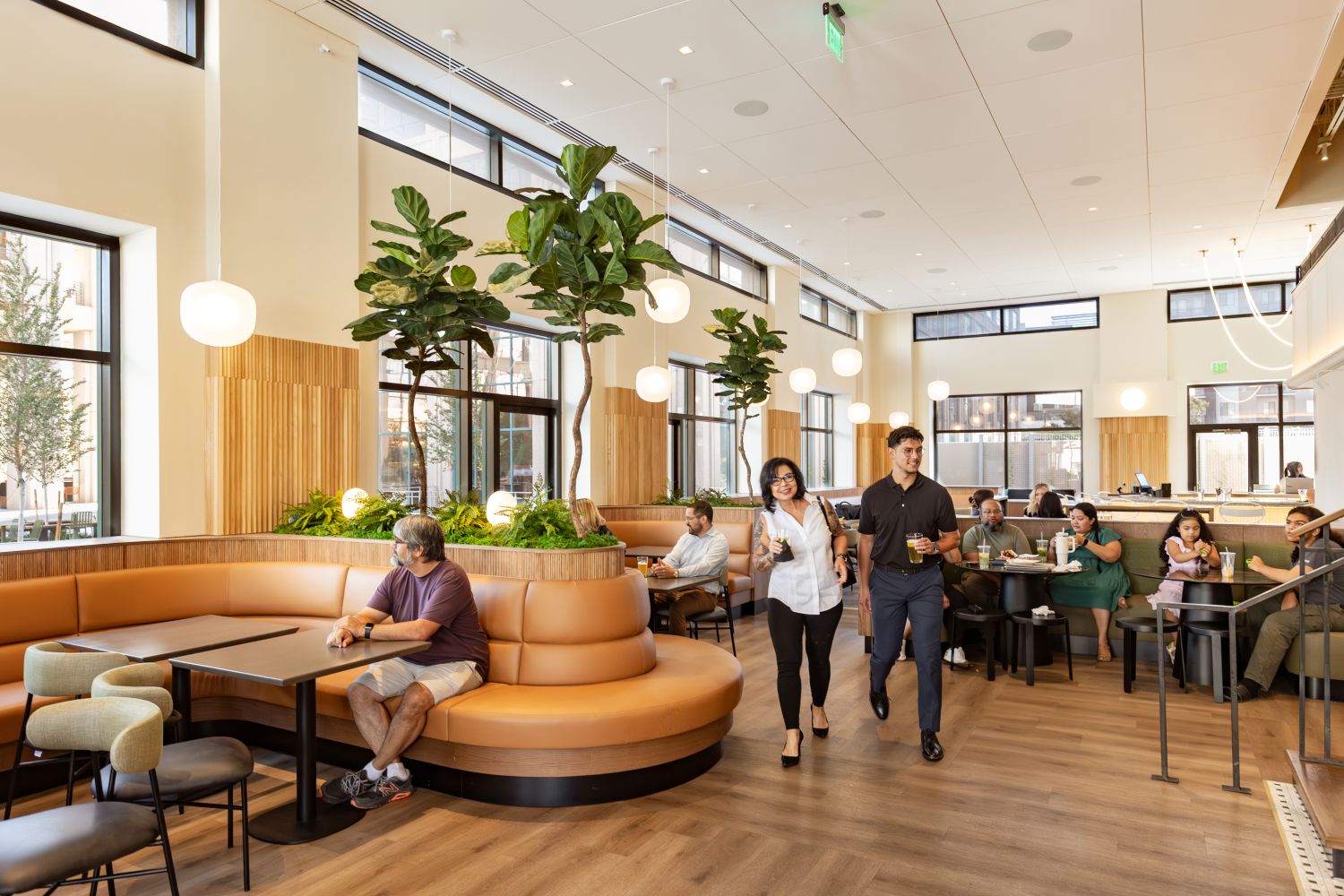 Interior of Park Square Market with two people walking in the center and people sat throughout
