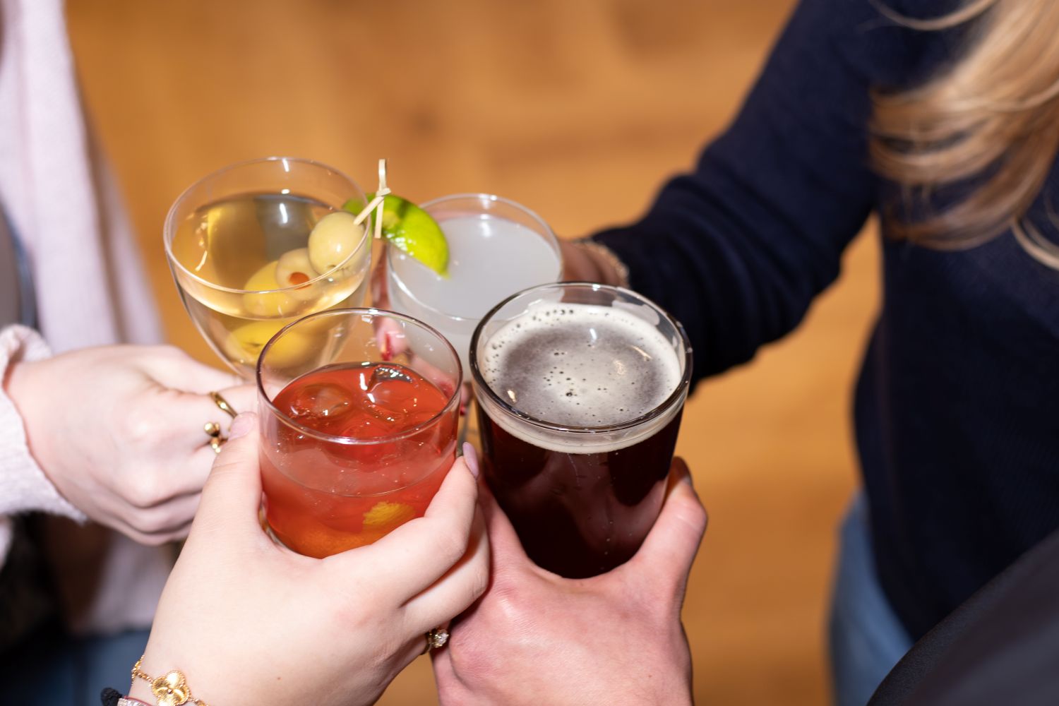 People cheershing with various cocktails
