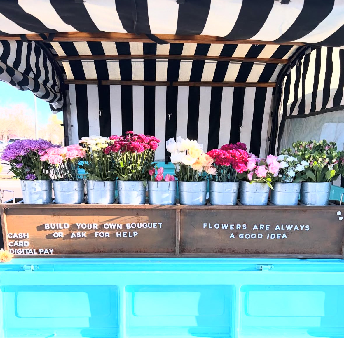Flower Display with signage saying "Flowers are always a good idea" and "Build your own bouquet or ask for help" 