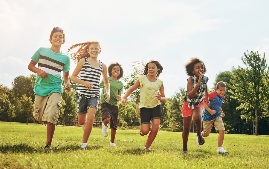 Kids running freely in a grass field in summer