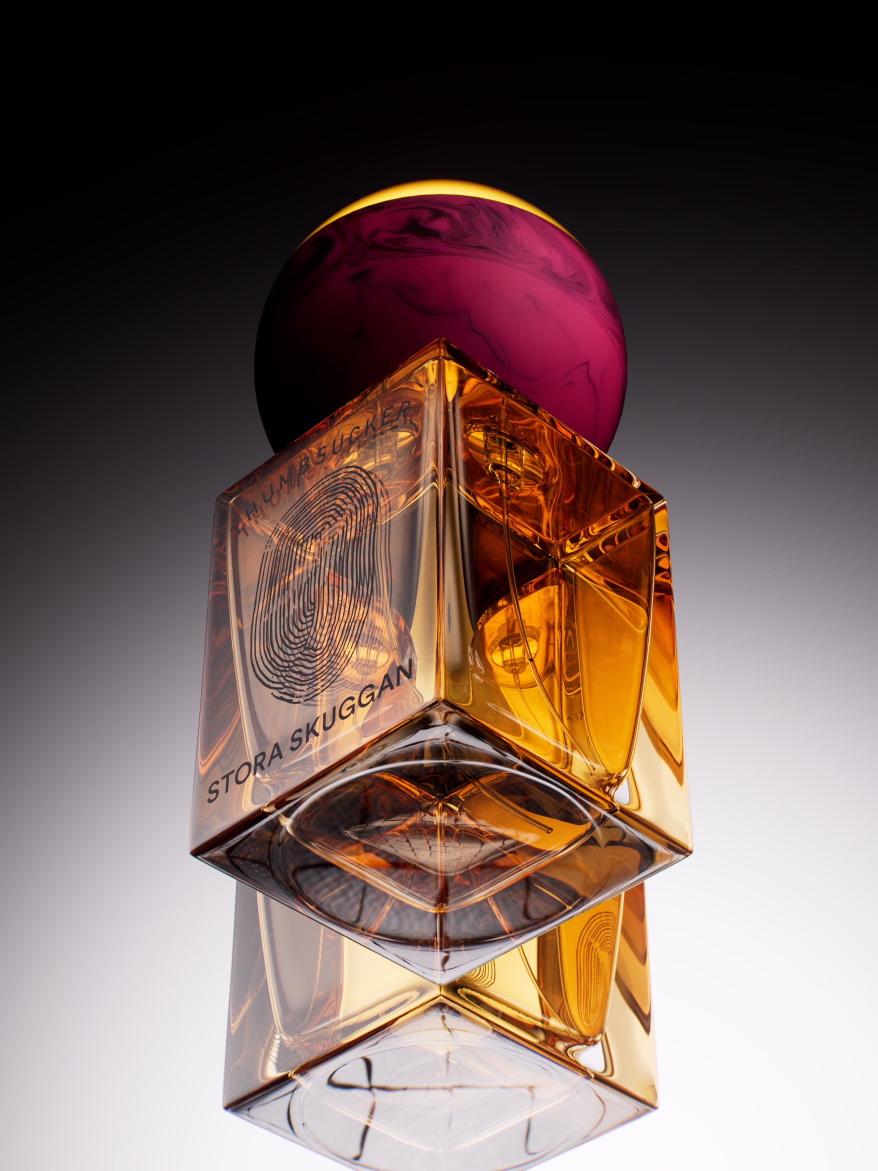 Amber glass bottle with a pink spherical cap and thumbprint design labeled Stora Skuggan.