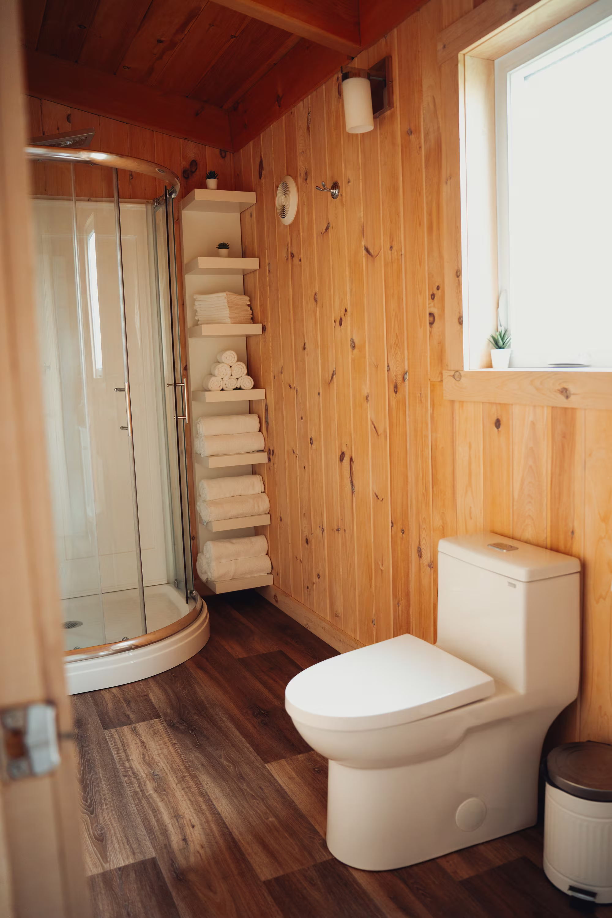 Salle de bain du chalet arrière avec douche arrondie et toilette