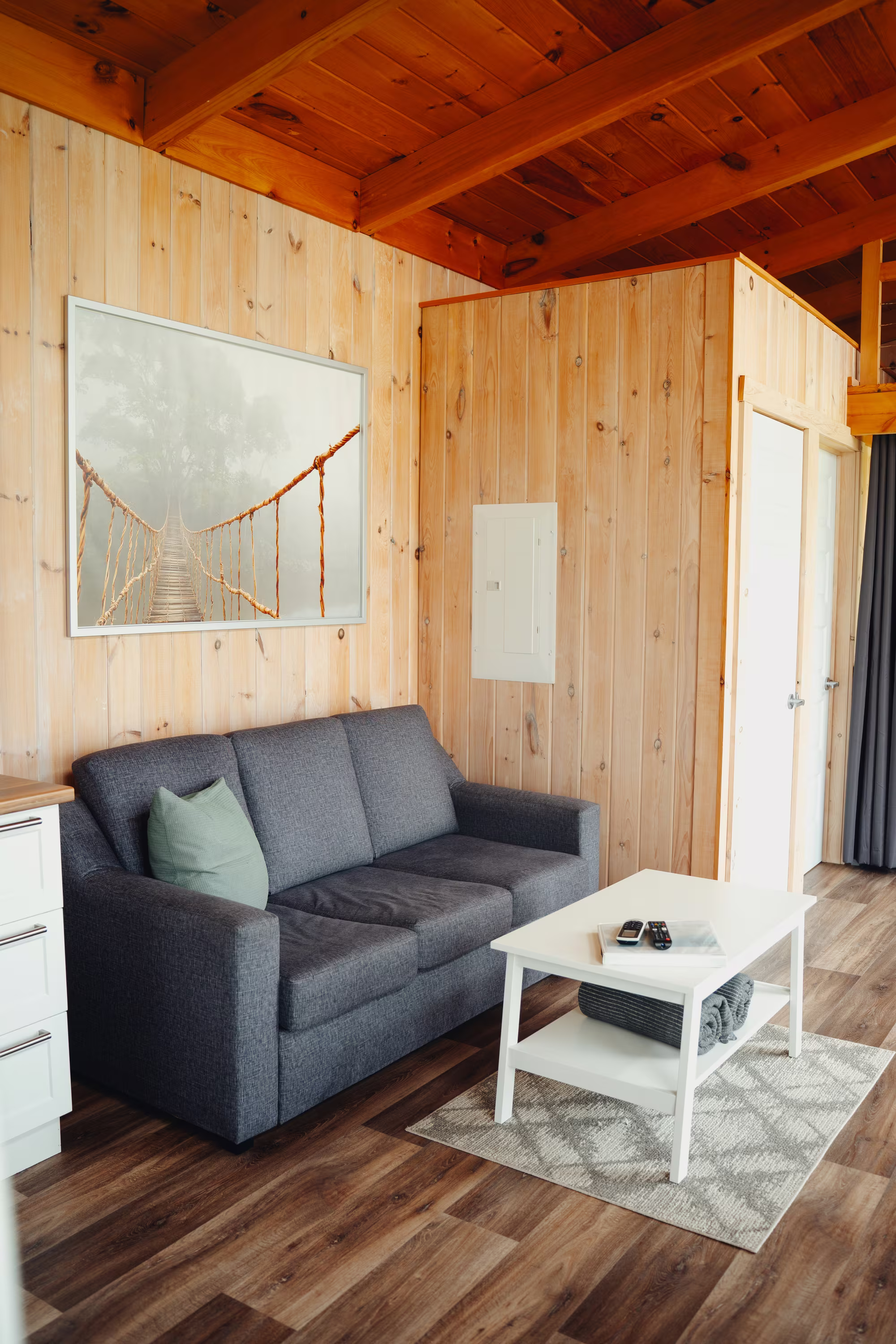 Salon du chalet arrière avec divan et table basse sous le plafond de bois
