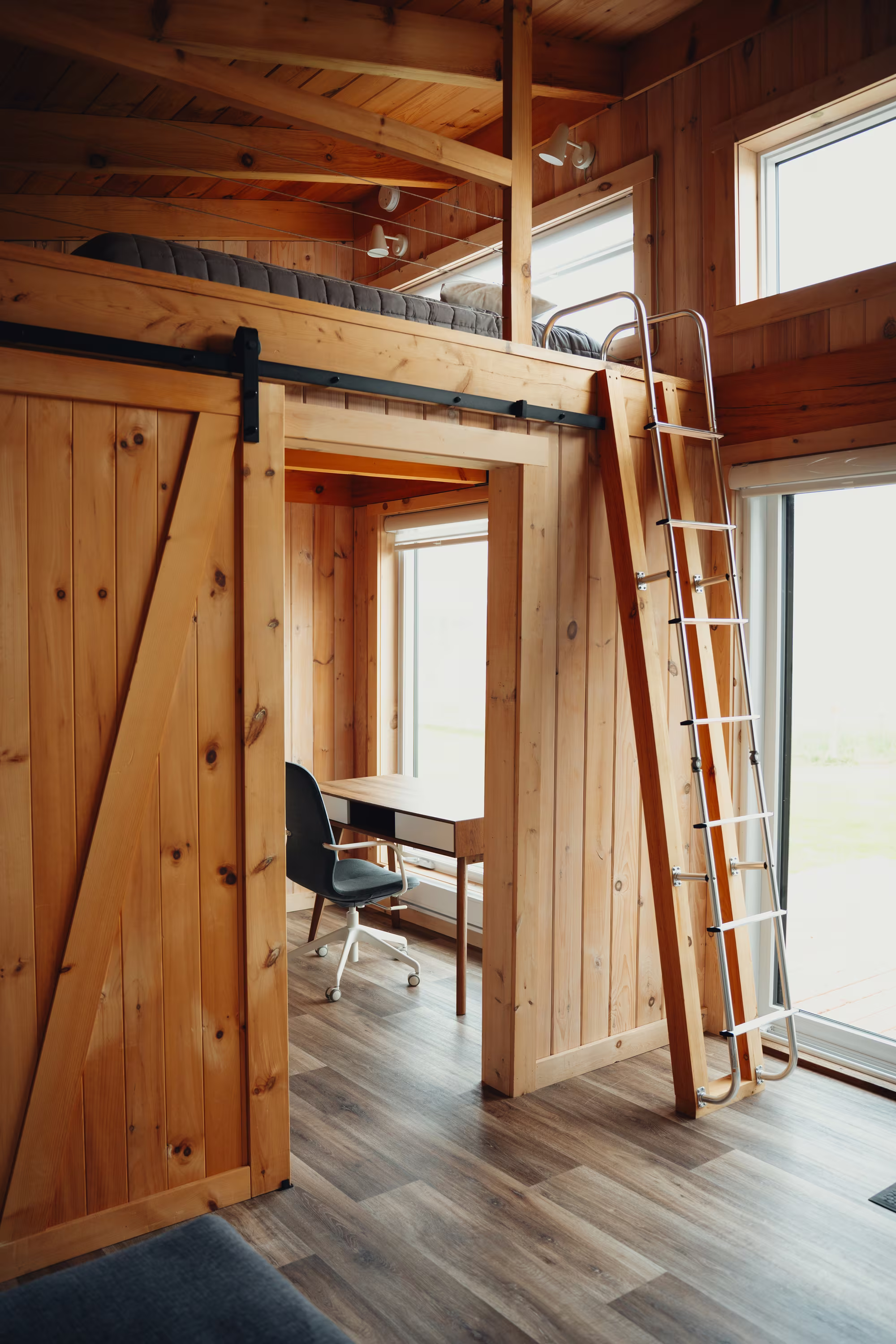 Mezzanine du chalet arrière accessible par échelle, avec coin bureau