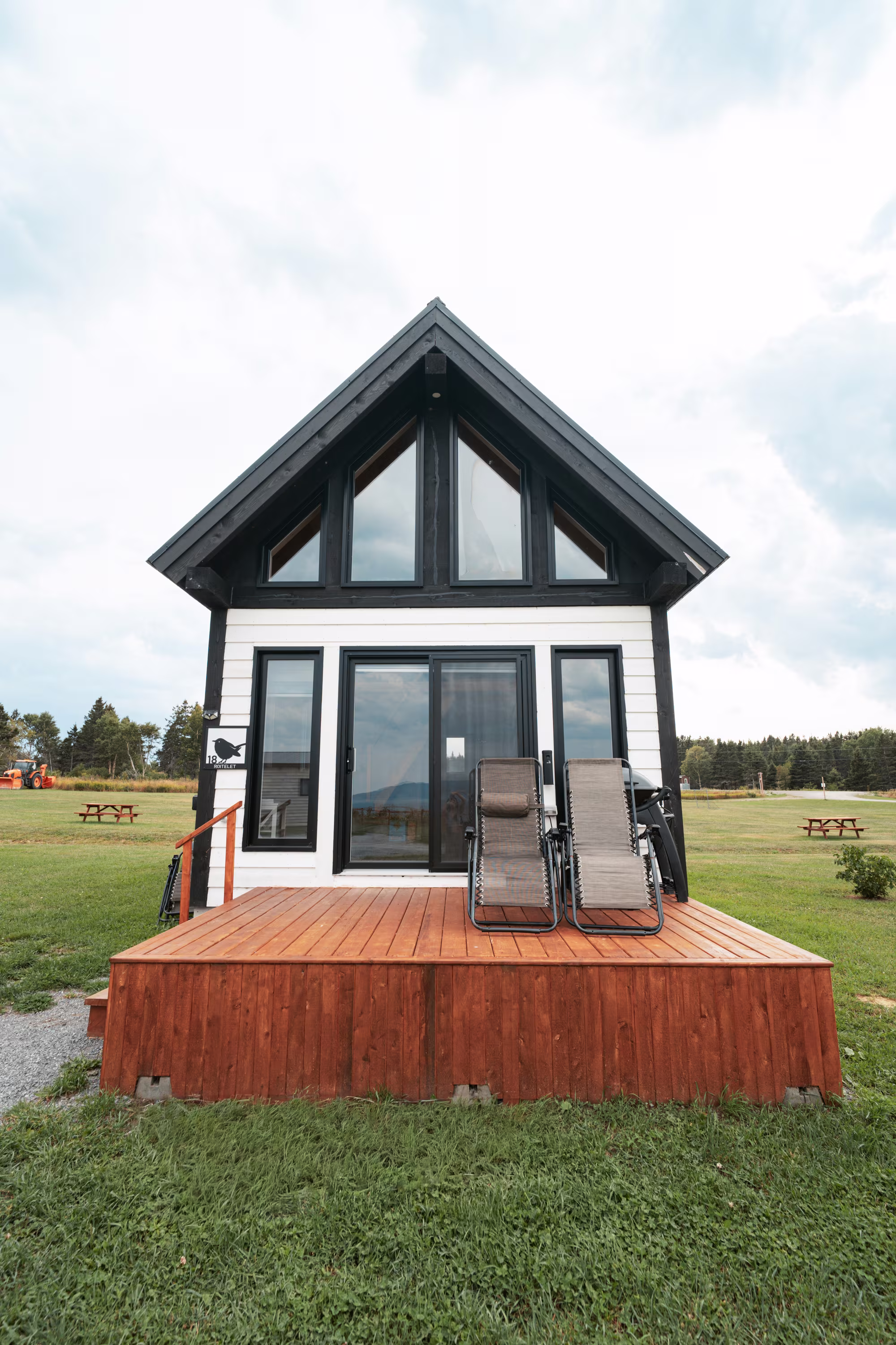 Chalet style suisse à toit en pignon, façade vitrée et terrasse de bois