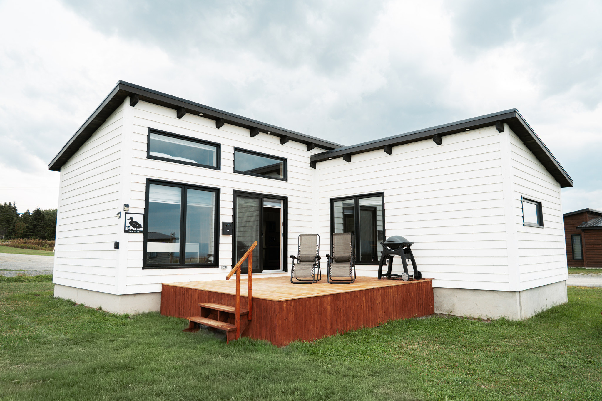 Extérieur d'un chalet double à revêtement pâle avec terrasse