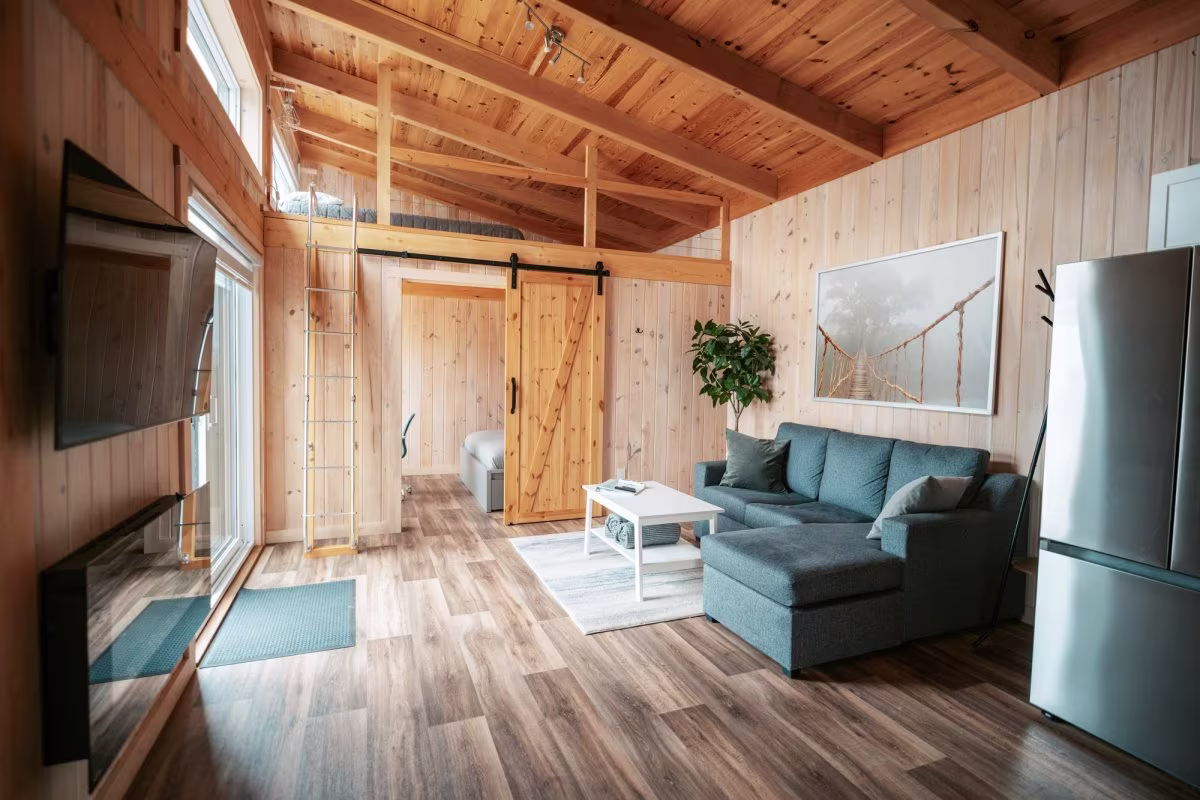 Das Wohnzimmer mit seiner auf Schienen laufenden Scheunentür, die zum Schlafzimmer des hinteren Doppelchalets führt